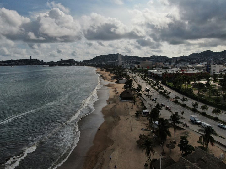 Tourists stroll along the beach shore before the arrival of Hurricane Erick, in Acapulco, Mexico, on June 18, 2025.
